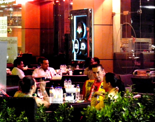 Men and women hang out at a cafe in Dubai. many cafes are open till 4am or through the night.